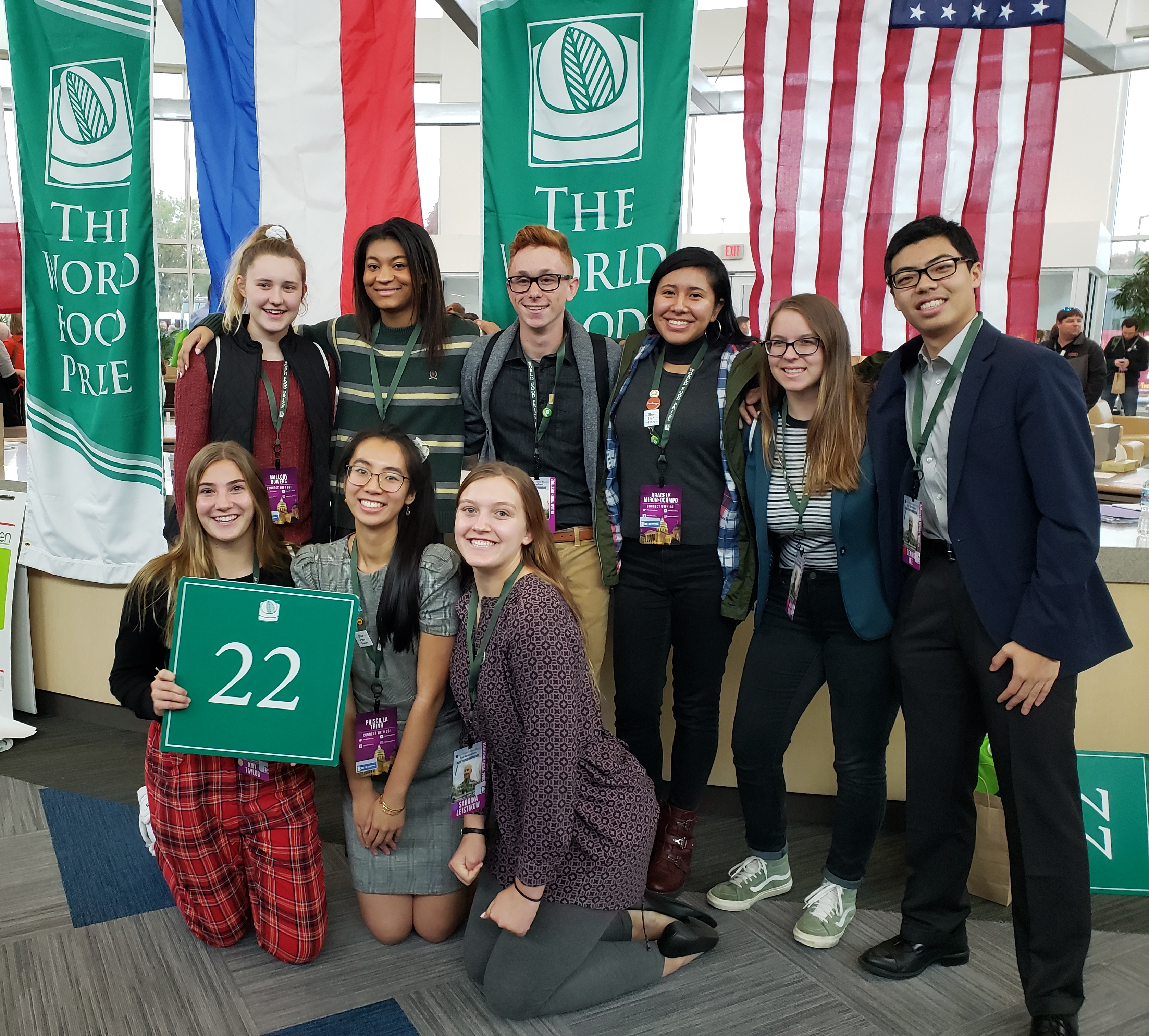 A group of multicultural students posing in front of international flags